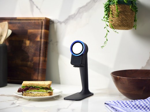 The Trepo device on its countertop stand beside a chopping board and a plate