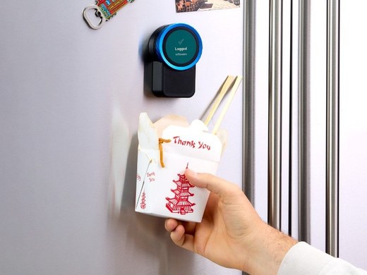 The Trepo device on a fridge door, logging a takeout container held up to it
